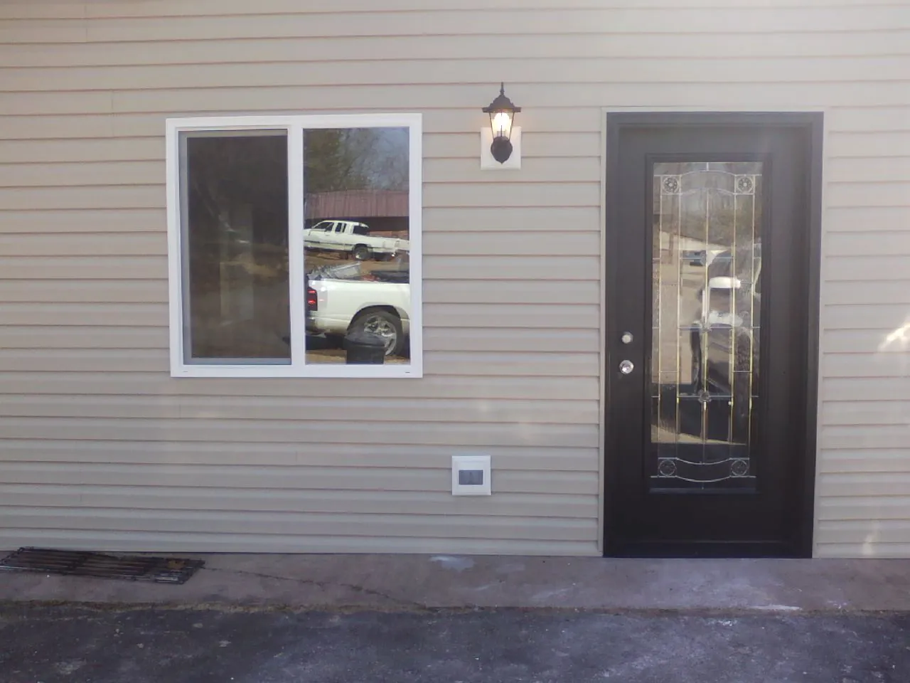 New siding, window and entry door on the side of an addition in Haverford