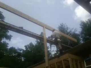 Carpenter setting a ridge beam over a new addition frame — Ice Dam Removal by Roofing Brothers in Haverford
