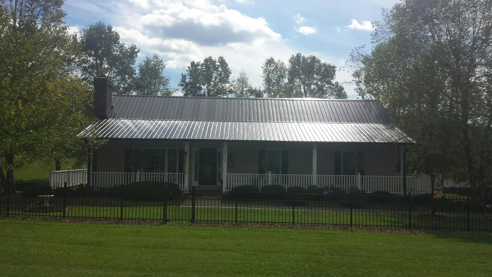 Gray metal roof on a brick ranch with a full width front porch — Gutter Guard Installation work by our crew in Haverford
