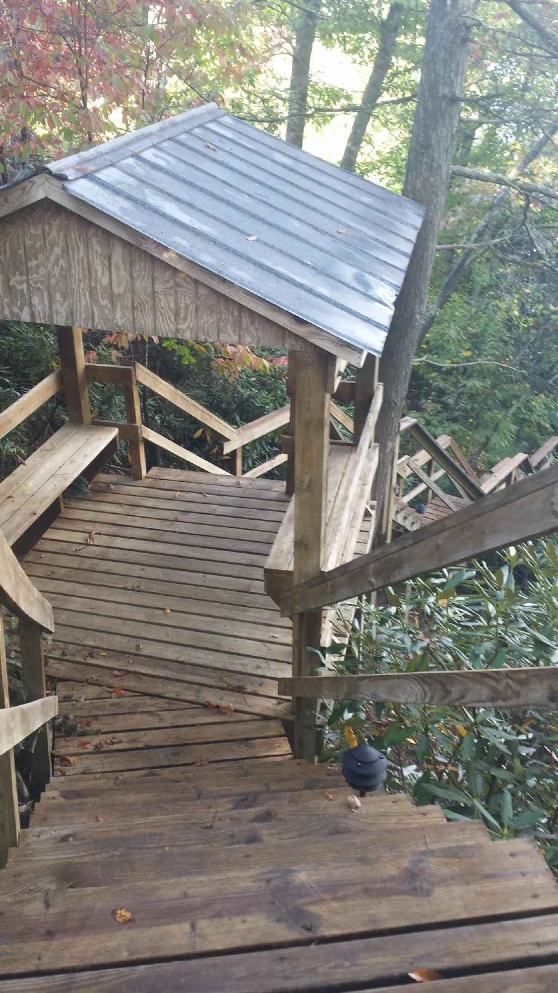 Metal roofed shelter over wooden steps on a wooded walkway — Skylight Repair & Installation work by our crew in Haverford