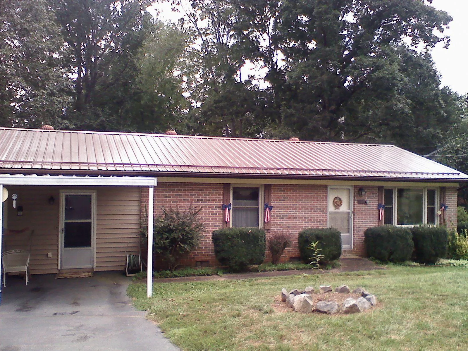 Bronze metal roof and carport on a brick ranch home — Roof Repair work by our crew in Haverford